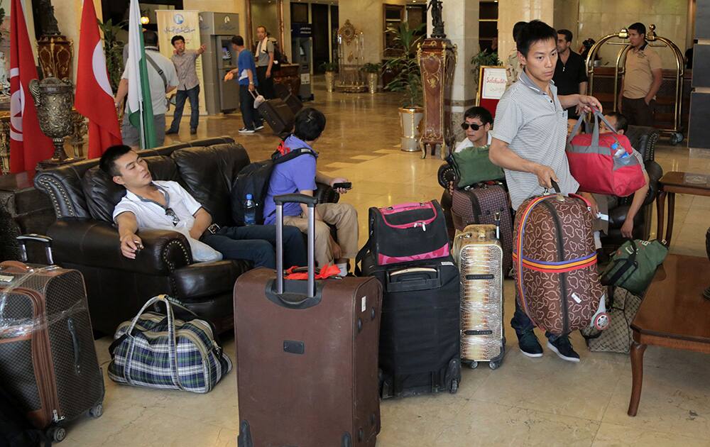 Chinese workers who fled from Samarra, Iraq, wait for buses to begin their journey home as they sit at a hotel in Baghdad, Iraq.