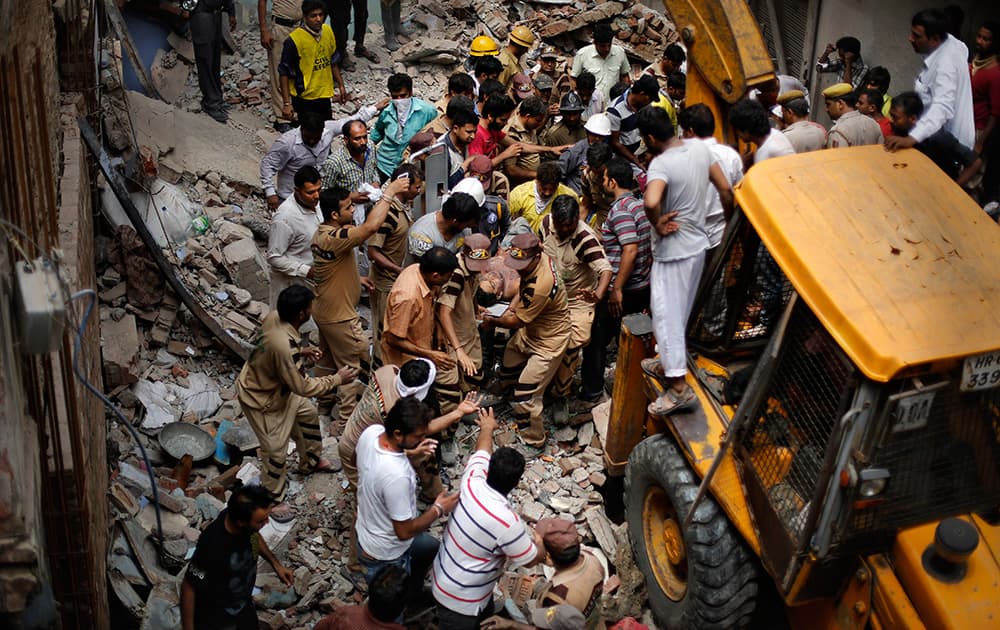 Rescue workers carry the body of a victim out of the debris of a building that collapsed in New Delhi.