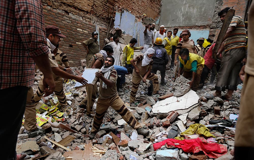 Rescue workers clear debris at the site of a building collapse in New Delhi.