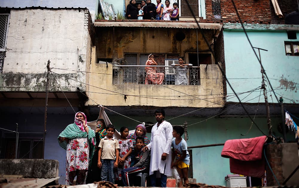 People watch rescuers work at the site of a building that collapsed in New Delhi.