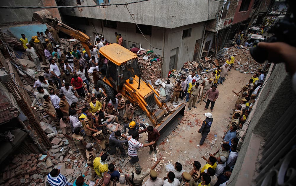 Rescue workers carry the body of a victim out of the debris of a building that collapsed in New Delhi.