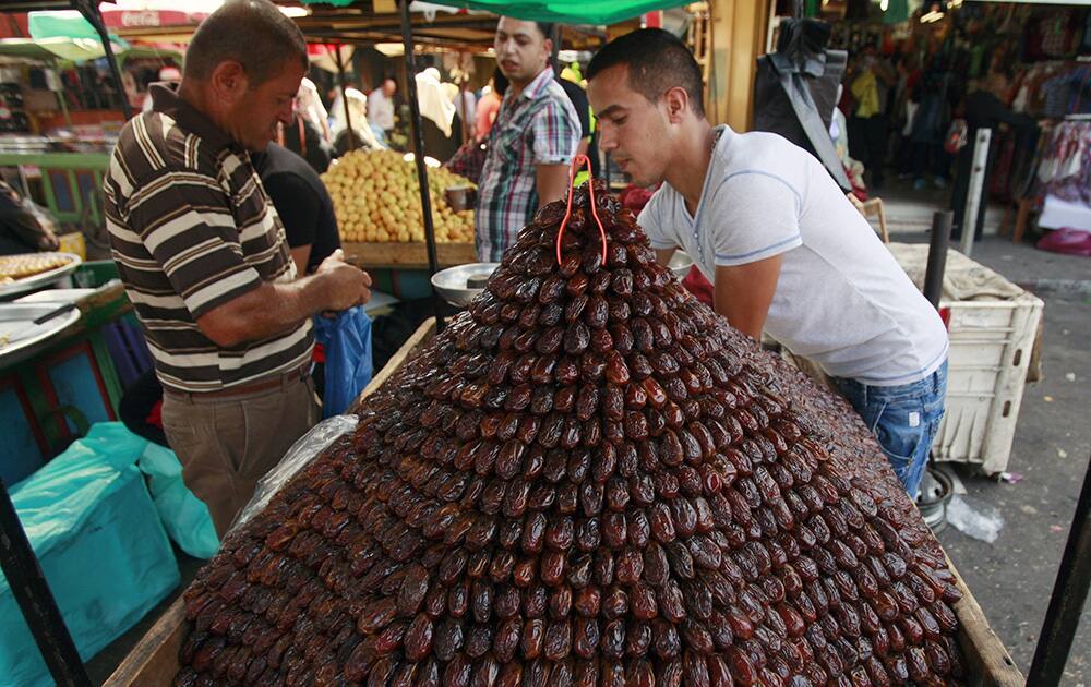 A Palestinian vendor sells dates for Ramadan at a market in the West Bank city of Jenin ahead of Ramadan. Muslims throughout the world are preparing themselves before the holy month of Ramadan, where observants fast from dawn till dusk.