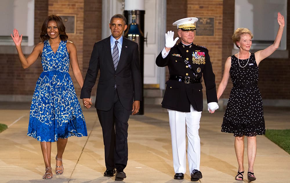 President Barack Obama and first lady Michelle Obama are escorted to their seats by Marine Commandant Gen. James Amos and his wife Bonnie Amos during the Marine Barracks Evening Parade in Washington.