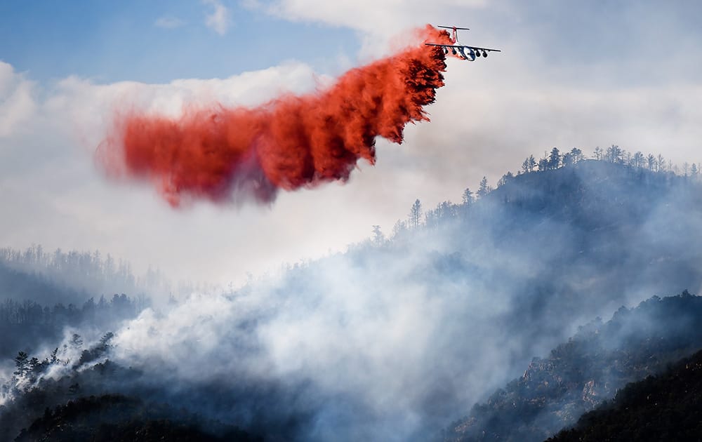 A slurry bomber makes a drop on the Eightmile Fire, north of Canon City, Colo. Fire information officer Dusty Romero said fire managers on scene have requested at least an additional 80 firefighters.