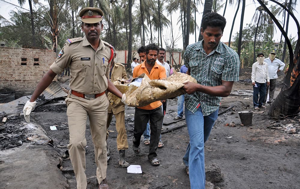 Police officers and rescue workers carry the body of a pipeline blast victim in Nagaram village, Andhra Prades. A state-owned gas pipeline exploded and burst into flames Friday, killing at least 15 people, destroying homes and forcing the evacuation of neighboring villages.