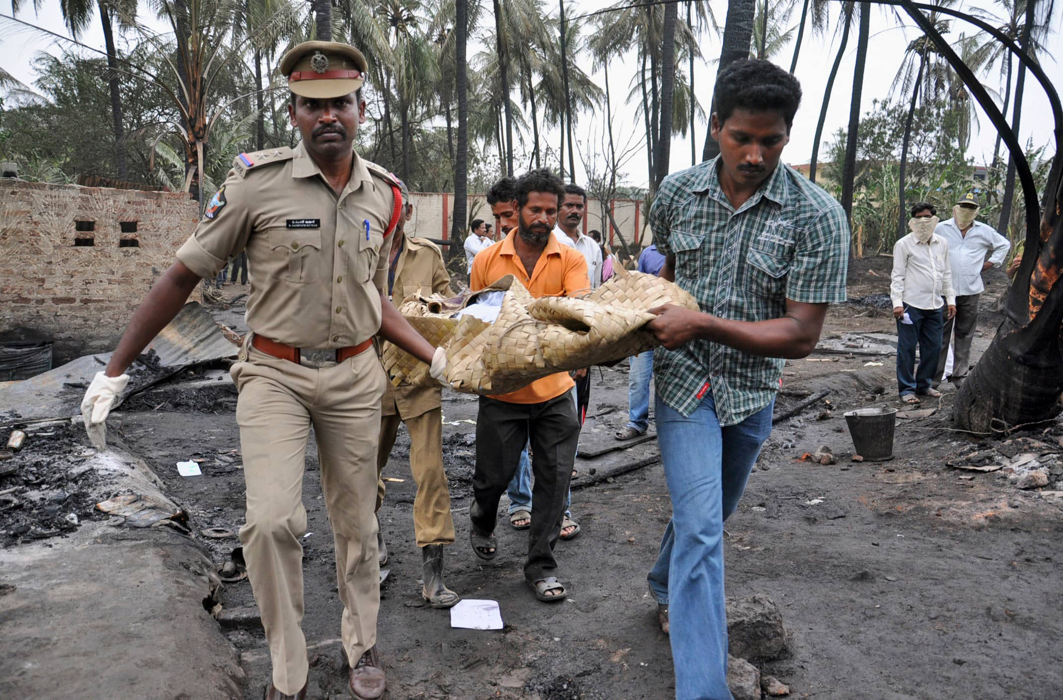 Police officers and rescue workers carry the body of a pipeline blast victim in Nagaram village, Andhra Pradesh. A state-owned gas pipeline exploded and burst into flames, killing at least 15 people, destroying homes and forcing the evacuation of neighboring villages in Andhra Pradesh.