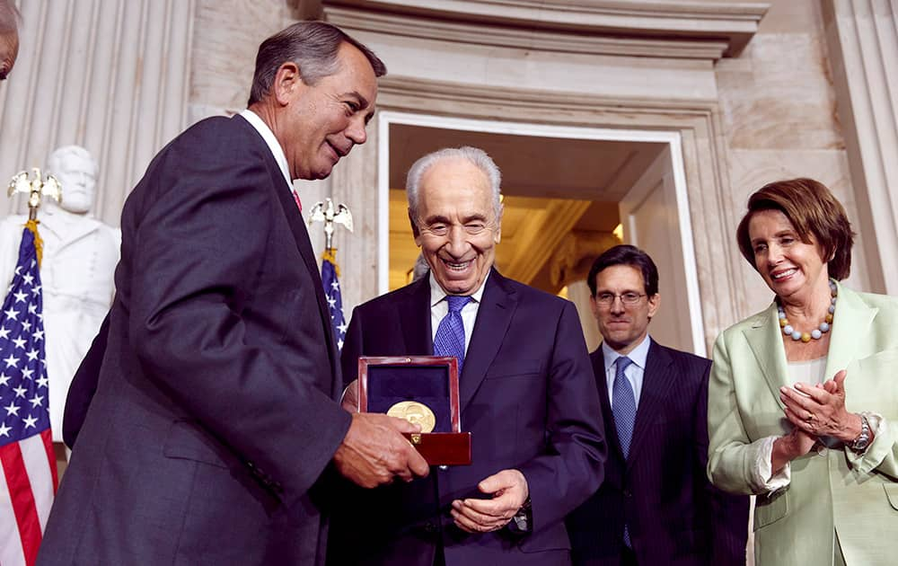 Israeli President Shimon Peres is honored with the Congressional Gold Medal, presented by House Speaker John Boehner of Ohio, as House Majority Leader Eric Cantor of Va., and House Minority Leader Nancy Pelosi of Calif., applaud at right.