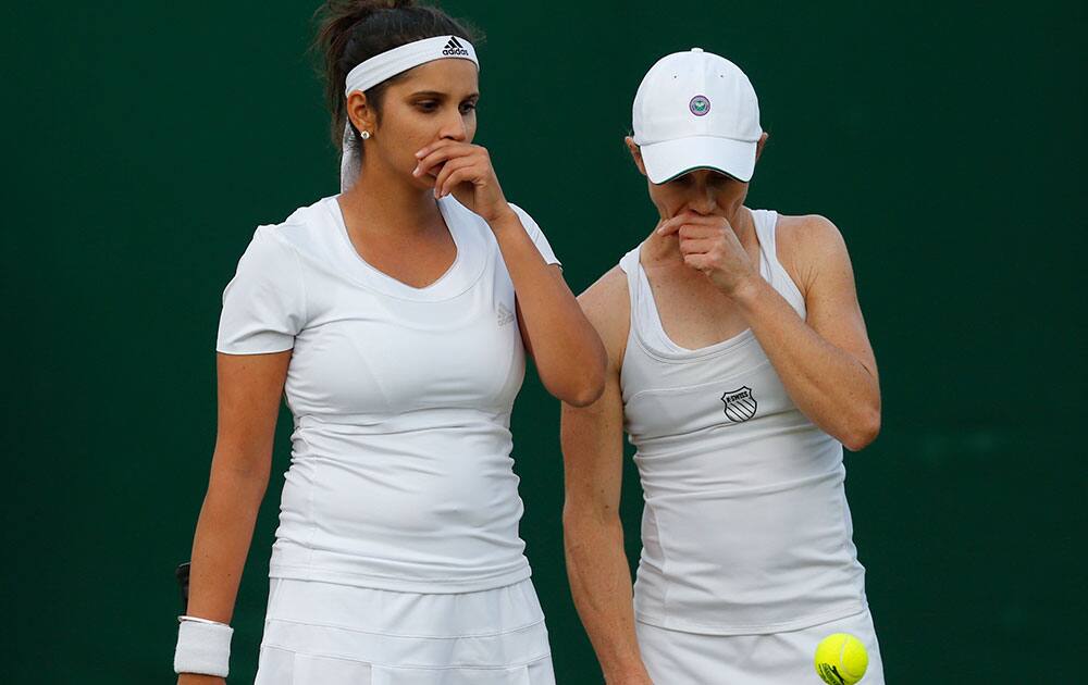 Sania Mizra of India, left, and playing partner Carla Black of Zimbabwe talk tactics as they play against Martina Hingis of Switzerland, and Vera Zonareva of Russia during the women`s doubles match at the All England Lawn Tennis Championships in Wimbledon.