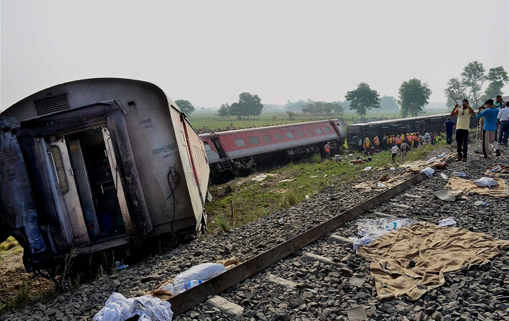 Rescue work continues while people look at the derailed Delhi-Dibrugarh Rajdhani Express near Chapra in Bihar.