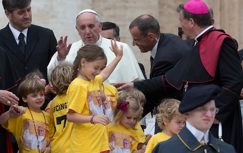 Pope Francis hugs a group of Spanish children coming from Madrid at the end of his weekly general audience in St. Peter`s Square at the Vatican.