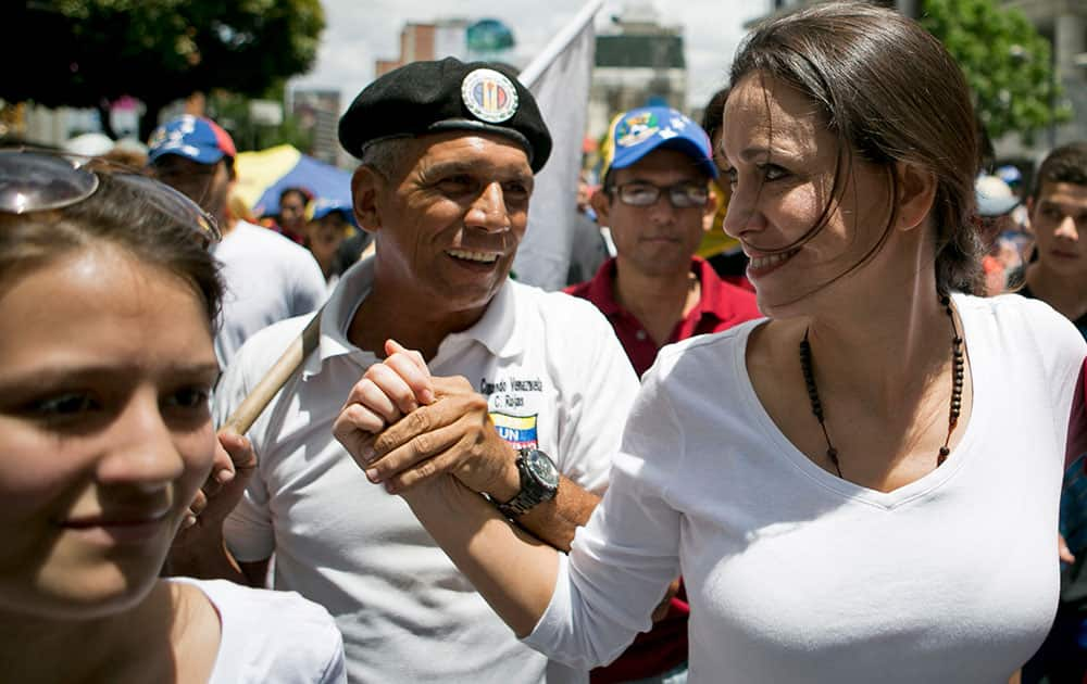 Opposition leader Maria Corina Machado, right, greets a supporter as she arrives to Altamira Square for a protest against the government of President Nicolas Maduro in Caracas, Venezuela.