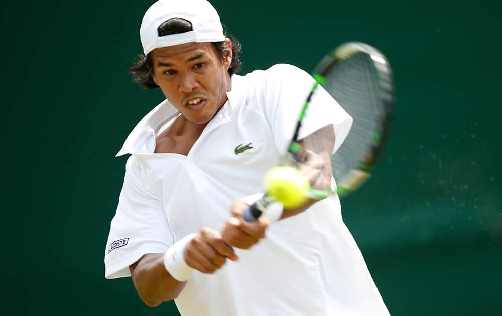 Somdev Devvarman of India plays a return to Jerzy Janowicz of Poland during their first round match at the All England Lawn Tennis Championships in Wimbledon, London.