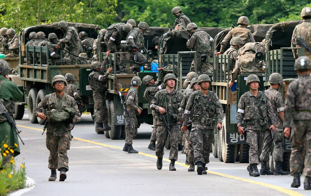 South Korean army soldiers exit their military trucks during an arrest operation in Goseong, South Korea.