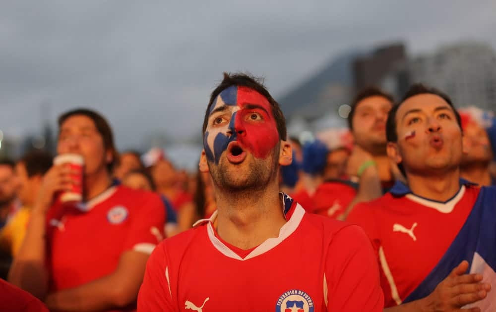 Soccer fans watch a live broadcast of the group B World Cup match between Chile and Spain, inside the FIFA Fan Fest area on Copacabana beach, in Rio de Janeiro, Brazil.