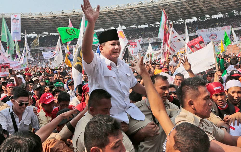 Indonesian presidential candidate Prabowo Subianto, center, is carried by his bodyguards as he greets his supporters during a campaign rally at Gelora Bung Karno Stadium in Jakarta, Indonesia.