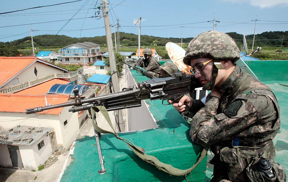 South Korean army soldiers aim their machine guns as they search for a South Korean conscript soldier who is on the run after a shooting incident in Goseong, South Korea.