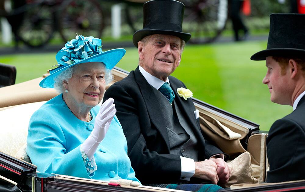 Britain`s Queen Elizabeth II, with Prince Philip and Prince Harry, right, arrive by carriage in the parade ring on the third day of the Royal Ascot horse racing meeting, which is traditionally known as Ladies Day, at Ascot, England.