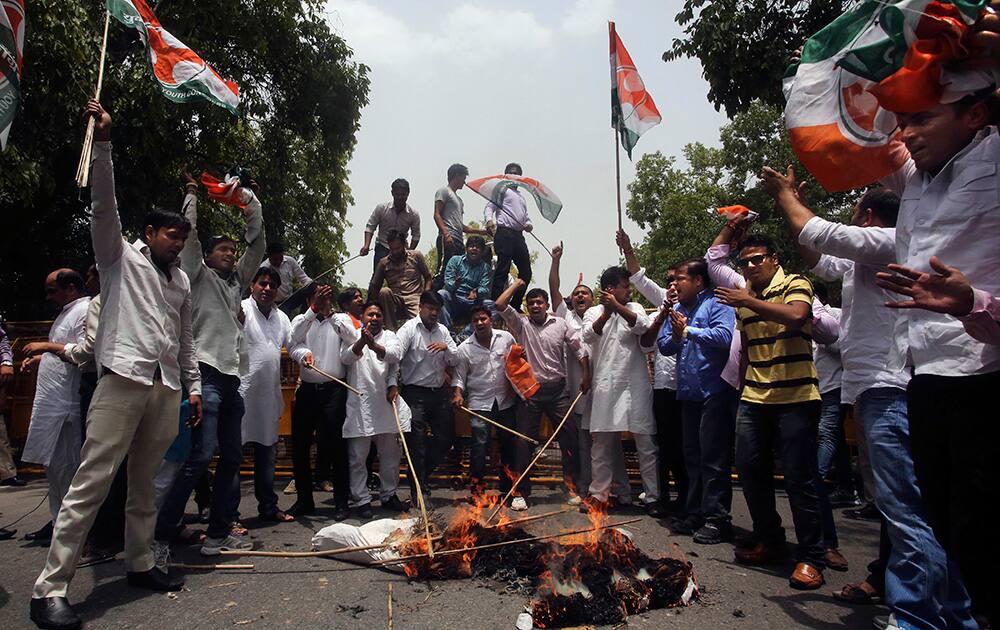 Supporters of Congress party shout slogans as they beat an effigy representing the Indian government during a protest against a recent price hike in railway fares, outside the office of railway ministry in New Delhi.