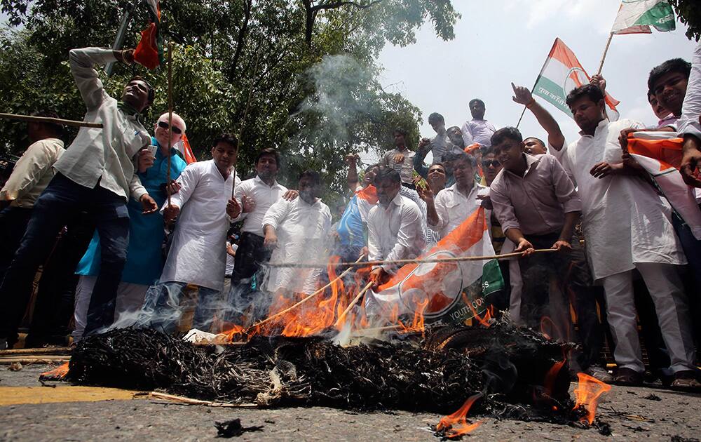 Supporters of Congress party beat an effigy representing the Indian government during a protest against a recent price hike in railway fares, outside the office of railway ministry in New Delhi.