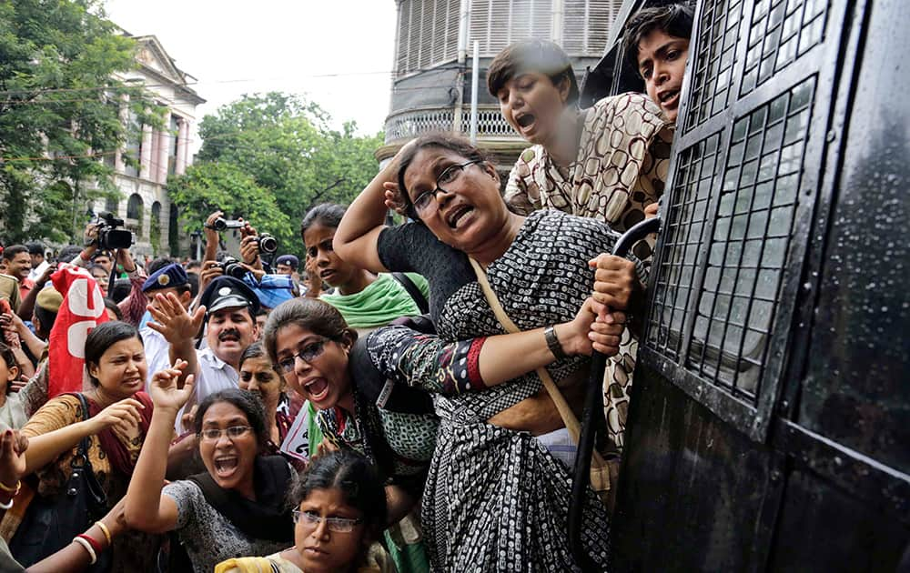 Activists of Socialist Unity Center of India (SUCI) shout slogans from a police van after being detained during a protest against hike in rail fare, outside the Governor`s house in Kolkata.