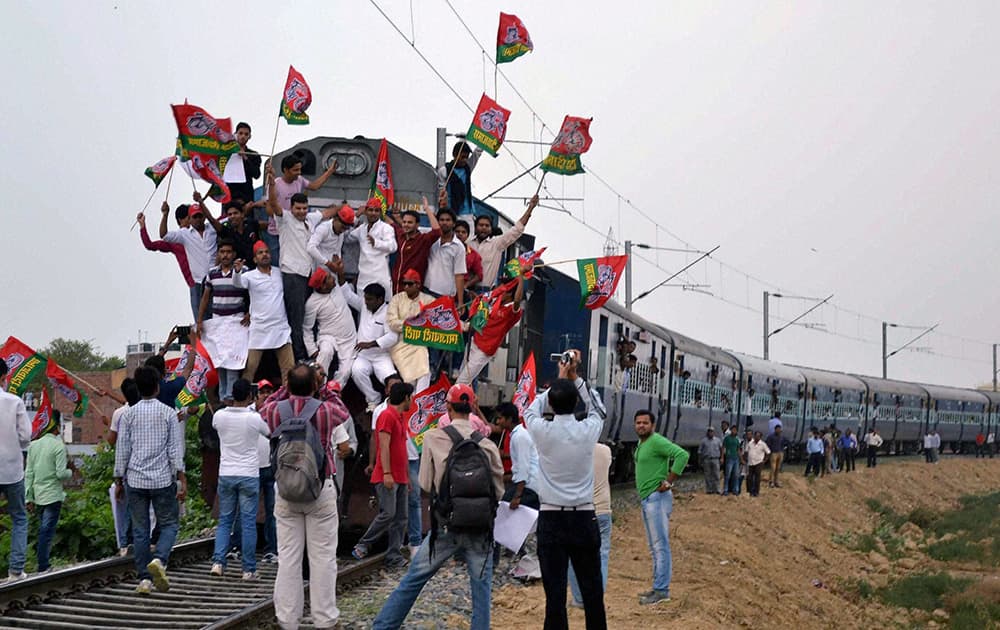 Samajwadi Party workers block a train in protest against hike in railway fares, in Allahabad.