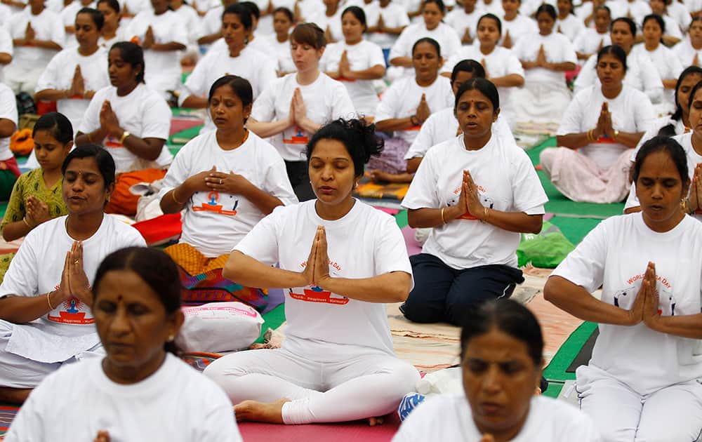 Yoga enthusiasts perform Surya Namaskar or sun salutation as they celebrate World Yoga Day in Bangalore.