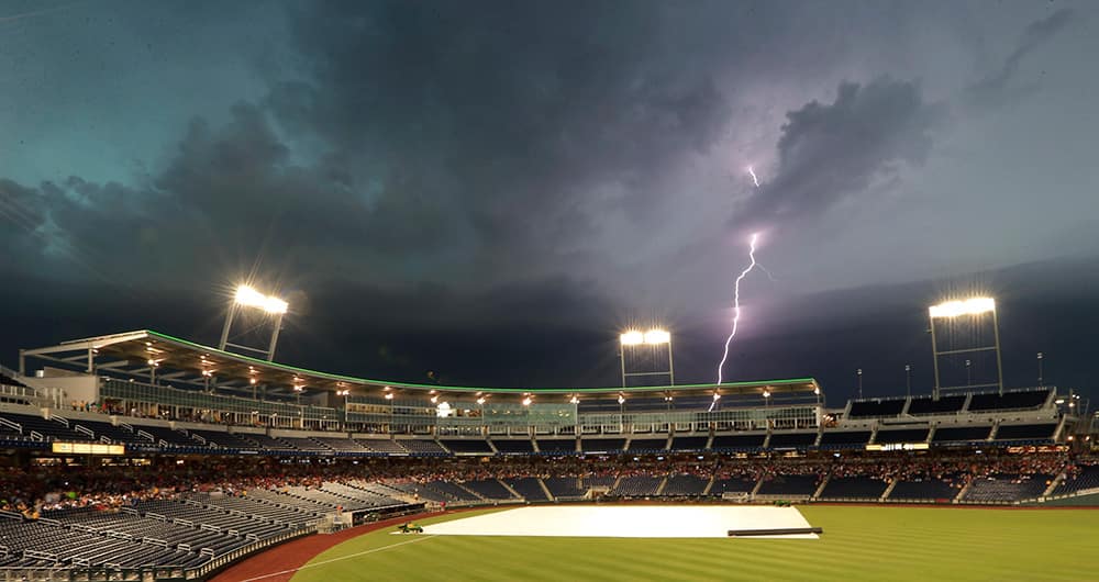 Lighting strikes near TD Ameritrade Park, during a weather delay in the baseball game between Virginia and Mississippi at the NCAA College World Series, in Omaha, Neb.