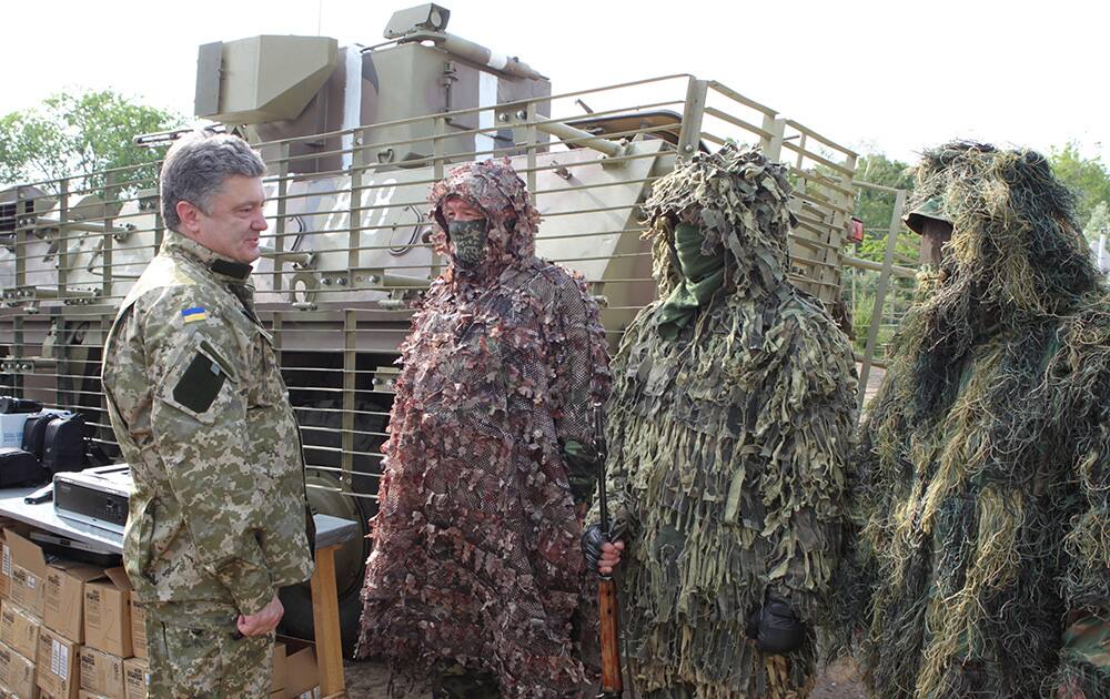 Ukrainian President Petro Poroshenko, left, talks with the Ukrainian soldiers at a military base close to Slovyansk, in the Donetsk region, Ukraine.