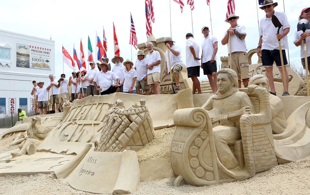 Competitors from around the world line up for a group photo to mark the opening day of the DO AC Sand Sculpting World Cup on the beach off Virginia Avenue, in Atlantic City.