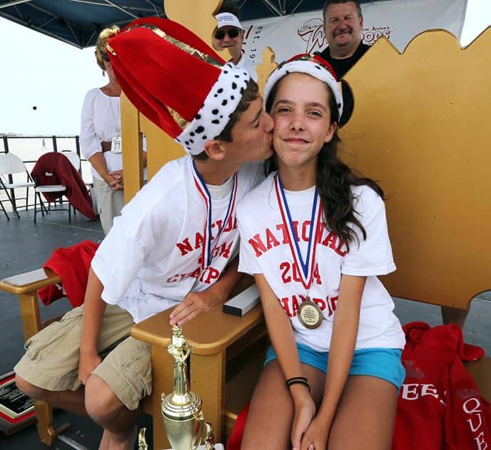 National Marbles Championship boys winner Dominic Rudakevych, 13, gives girls winner Marilyn Fisher, 13, both of Middletown, Md., the traditional kiss after the championship round of the 91st annual National Marbles Tournament at Ringer Stadium on the beach in Wildwood, N.J.