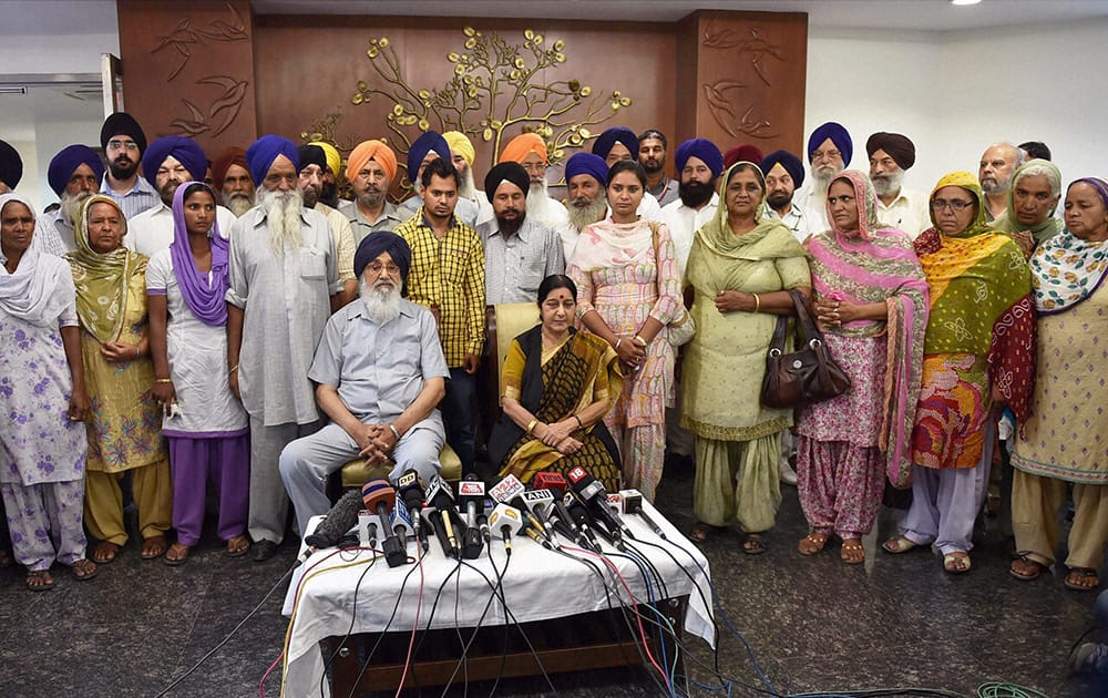 External Affairs Minister Sushma Swaraj and Punjab Chief Minister Parkash Singh Badal with the families of some of the Punjabi workers abducted in Iraq, in New Delhi.