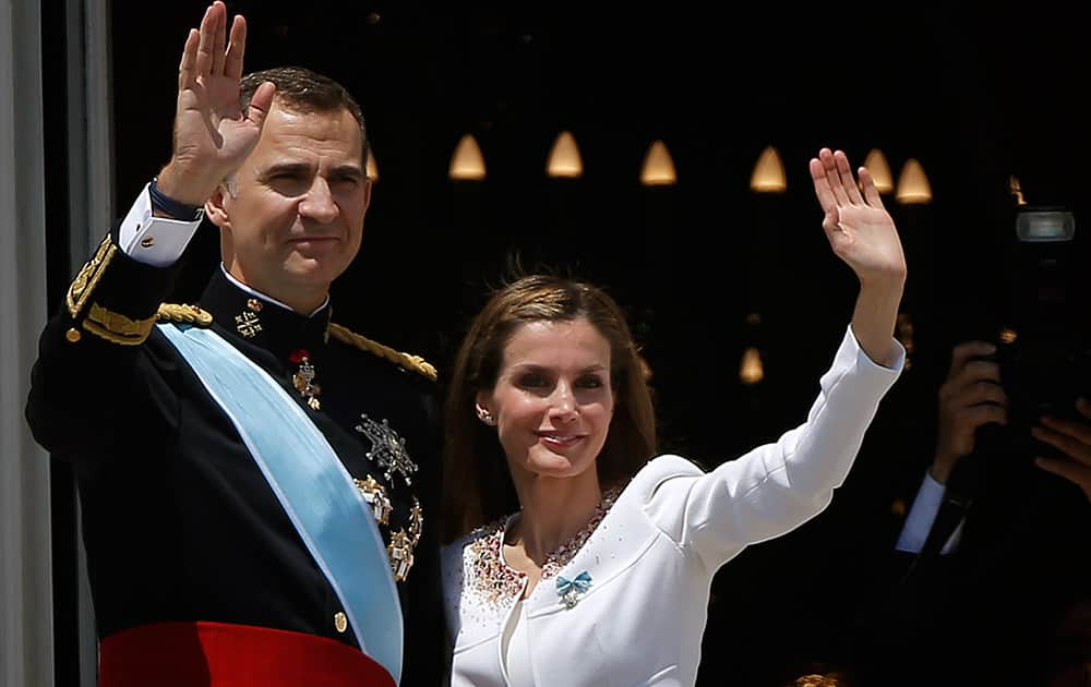 Spain’s newly crowned King Felipe VI and his wife Spain`s Queen Letizia wave to the crowd on a balcony of the Royal Palace in Madrid, Spain.