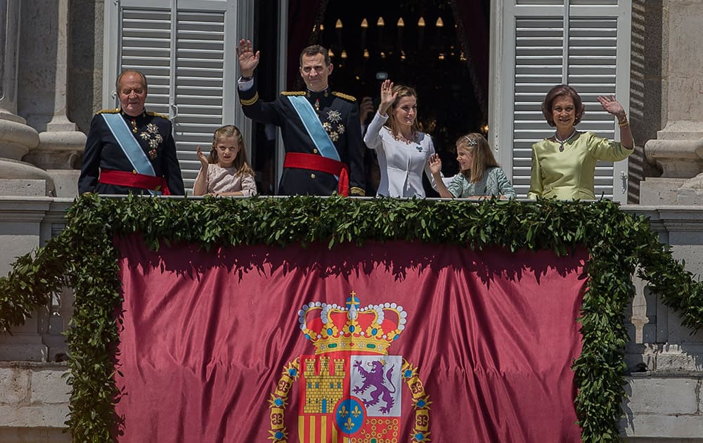 Spain’s newly crowned King Felipe VI, third left, his father Juan Carlos, left, his mother Sofia, right, Spanish Queen Letizia, third right, Spanish Princess Leonor, second left, and Spanish Princess Sofia, second right, wave from balcony of the Royal Palace in Madrid, Spain.