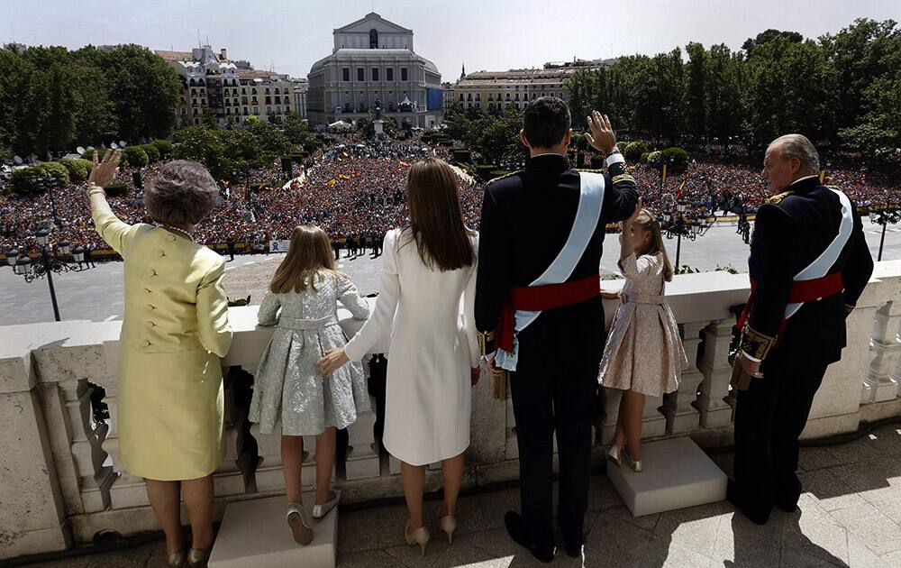 Spain’s newly crowned King Felipe VI, third right, his father Juan Carlos, right, his mother Sofia, left, his wife Spain`s Queen Letizia, third left, and his daughters Spain`s Princess Leonor, second right, and Spain`s Princess Sofia, second left, wave from a balcony of the Royal Palace in Madrid.