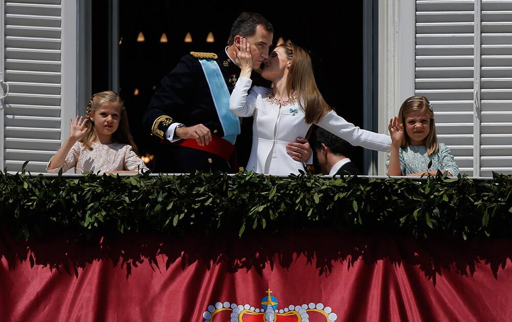 Spain’s newly crowned King Felipe VI is kissed by his wife Queen Letizia with their daughters Princess Sofia and Princess Leonor, left in a balcony of the Royal Palace in Madrid, Spain.