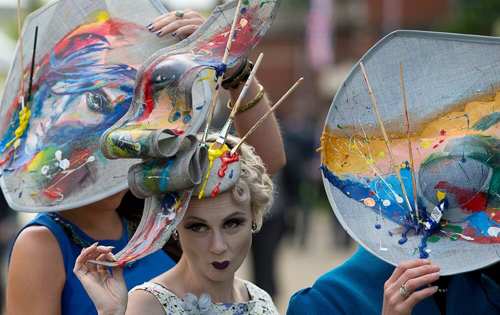 Constance Peach, centre, poses with friends for photographers on the third day of the Royal Ascot horse racing meeting, which is traditionally known as Ladies Day, at Ascot, England.