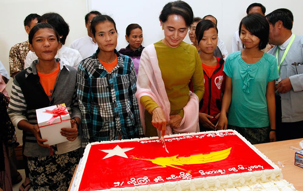 Myanmar`s opposition leader Aung San Suu Kyi, center, cuts her birthday cake during a ceremony to mark her 69th birthday at the Parliament building in Naypyitaw, Myanmar.