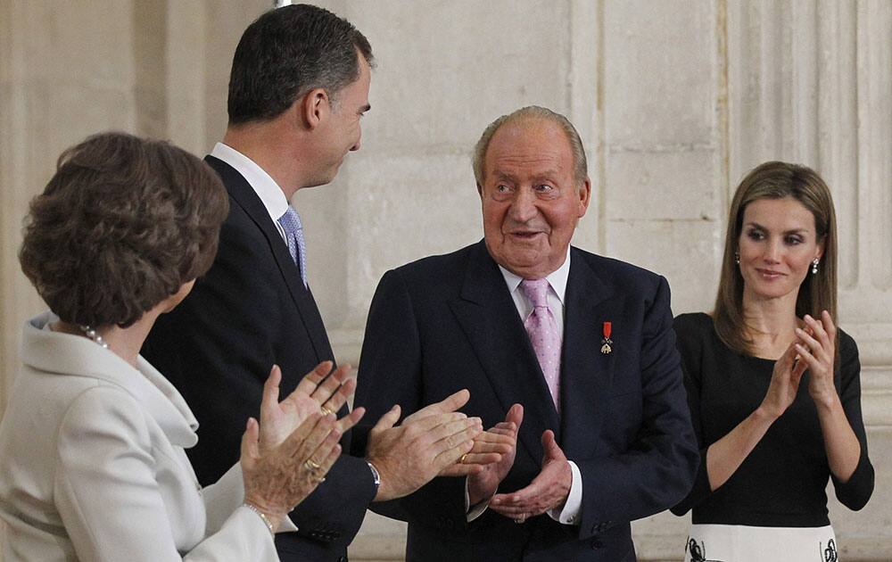 Spain’s King Juan Carlos, 3rd left is applauded by Queen Sofia, left, Spain`s Crown Prince Felipe, 2nd left and Princess Letizia after he signed an abdication law during a ceremony at the Royal Palace in Madrid, Spain.