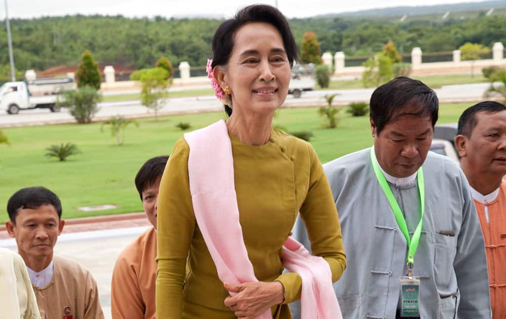 Myanmar opposition leader Aung San Suu Kyi, center, walks along with parliament members of her National League for Democracy party as she arrives for a parliament regular session in Naypyitaw, Myanmar. Suu Kyi celebrates her 69th birthday on Thursday. 