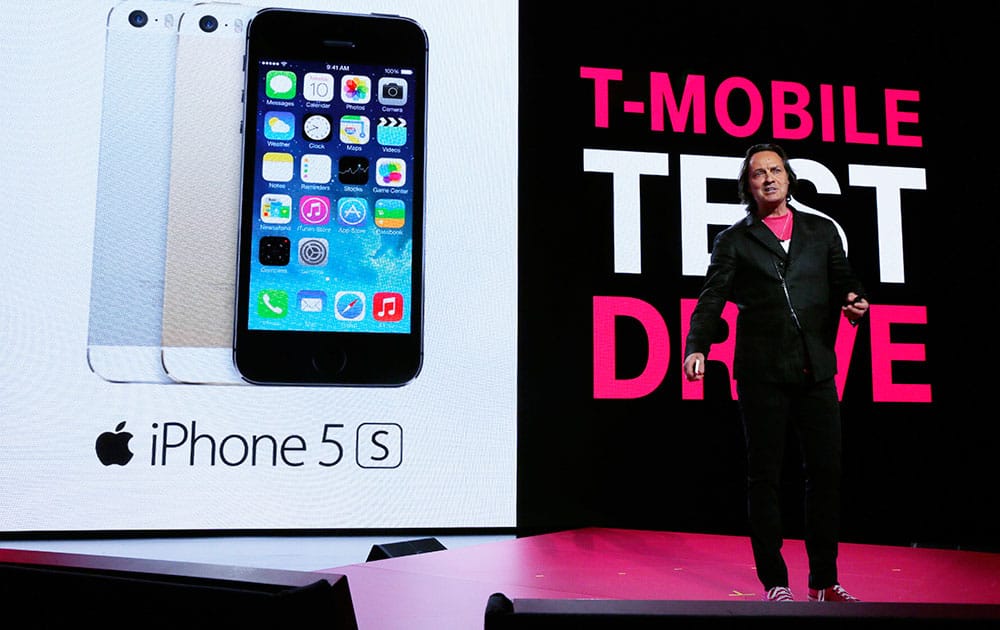 T-Mobile CEO John Legere talks about his company`s new program that offers a free seven-day test drive of an Apple iPhone 5S at T-Mobile`s Uncarrier 5.0 event, in Seattle.