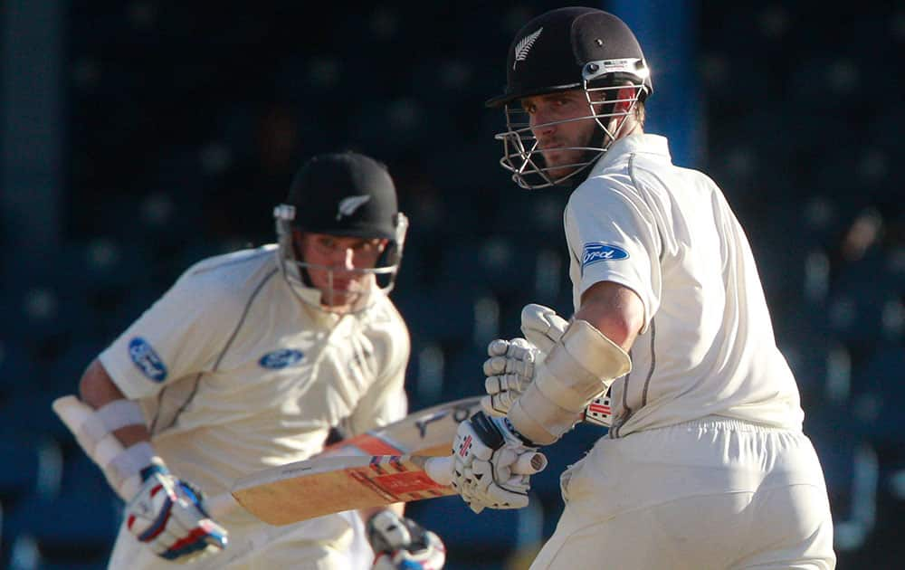 New Zealand batsmen Kane Williamson, right, and Tom Latham run between the wickets during the second innings on the third day of their second cricket Test match against West Indies in Port of Spain, Trinidad.