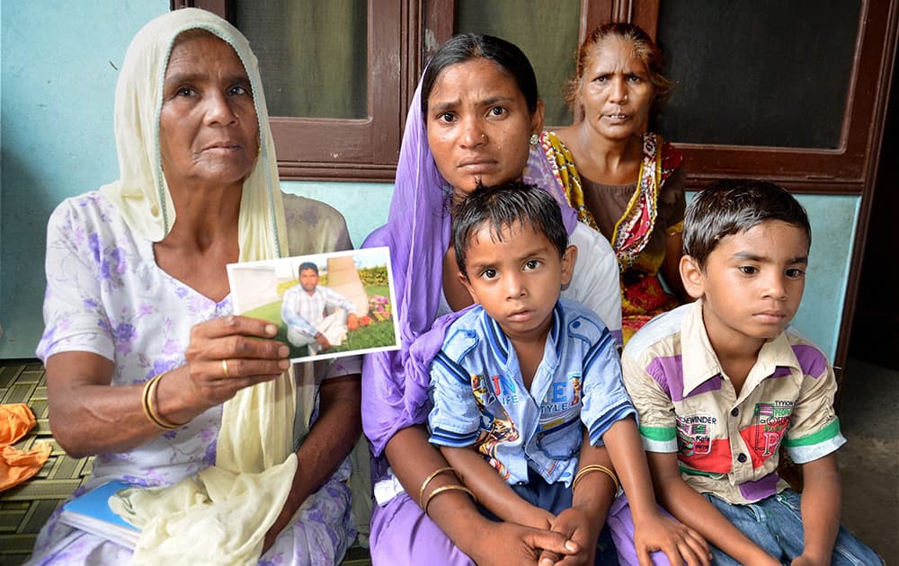 Family members of Sonu, believed to be trapped in the troubled city of Mosul (Iraq), showing his sons photograph in Amritsar.