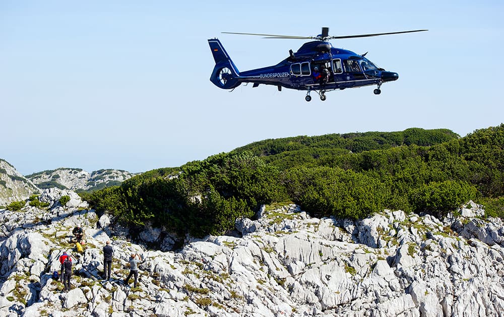 A police helicopter flies above rescuers at the Untersberg mountain near Marktschellenberg, Germany.