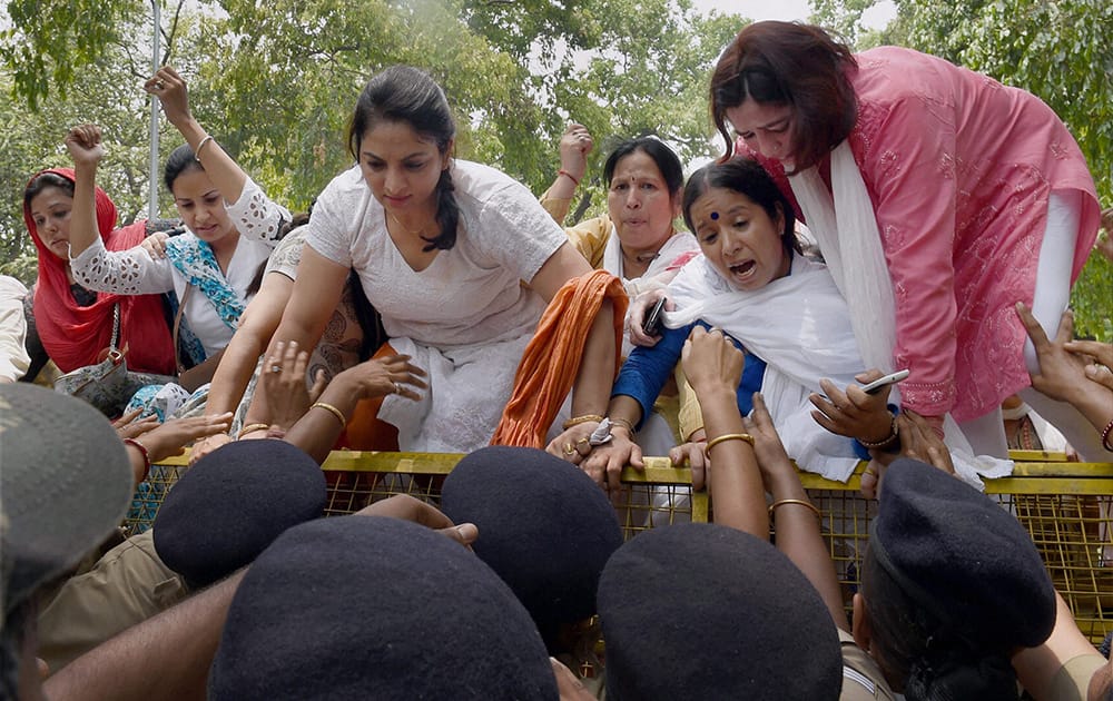 Women Congress workers try to break a barricade during a protest demanding resignation of Minister of State Nihal Chand in New Delhi.