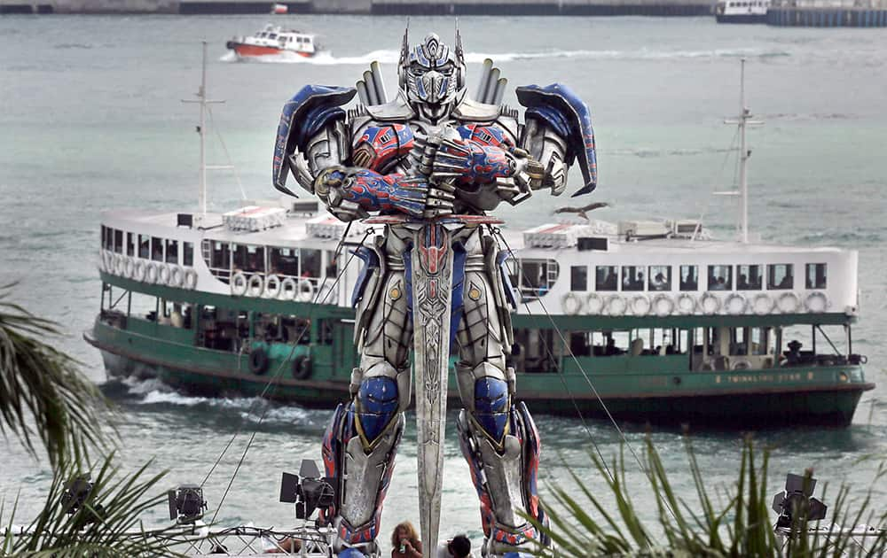 A ferry sails past a giant Transformer figure which is displayed against Victoria Habour in Hong Kong. World premiere of the movie Transformer is slated for Thursday in Hong Kong.