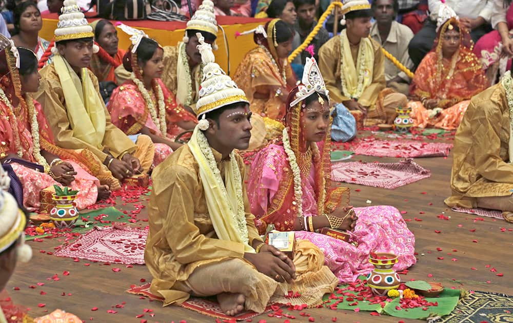 Brides and grooms sit together during a mass wedding organized by a social organization for sixty-five couple belonging to socially and economically backward communities in Kolkata.