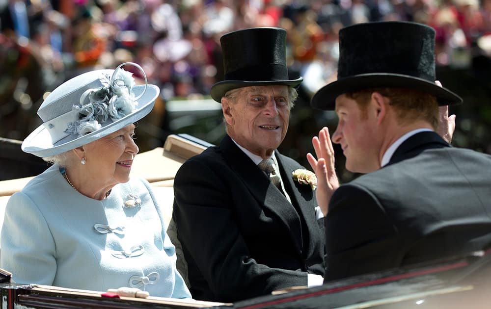 Britain`s Queen Elizabeth II, left, with Prince Philip, centre, and Prince Harry arrive by carriage on the first day of the Royal Ascot horse racing meeting at Ascot, England.