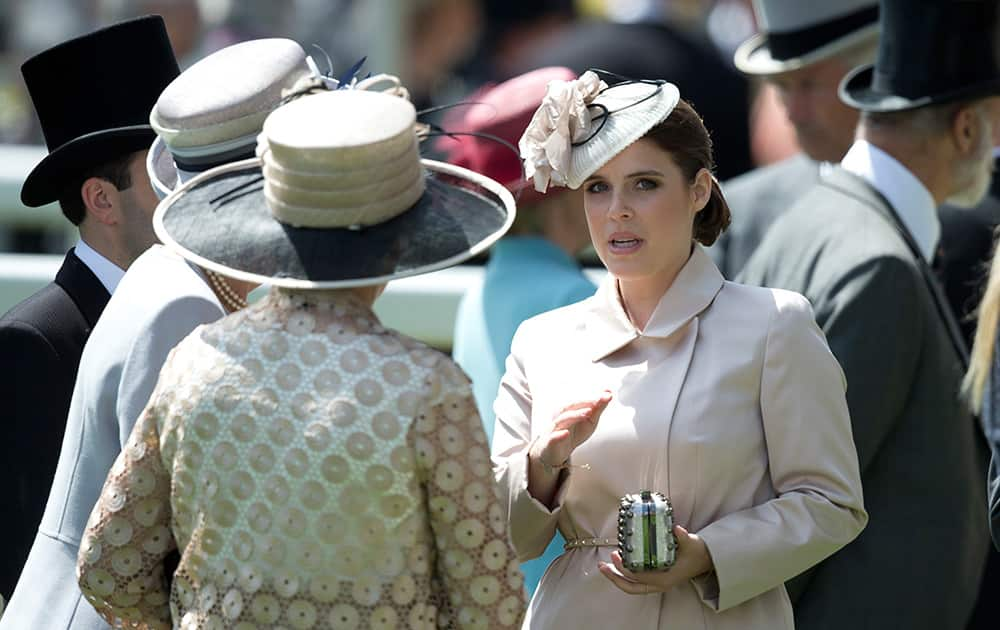 Britain`s Princess Eugenie, right, talks to friends in the parade ring on the first day of the Royal Ascot horse racing meeting at Ascot, England.