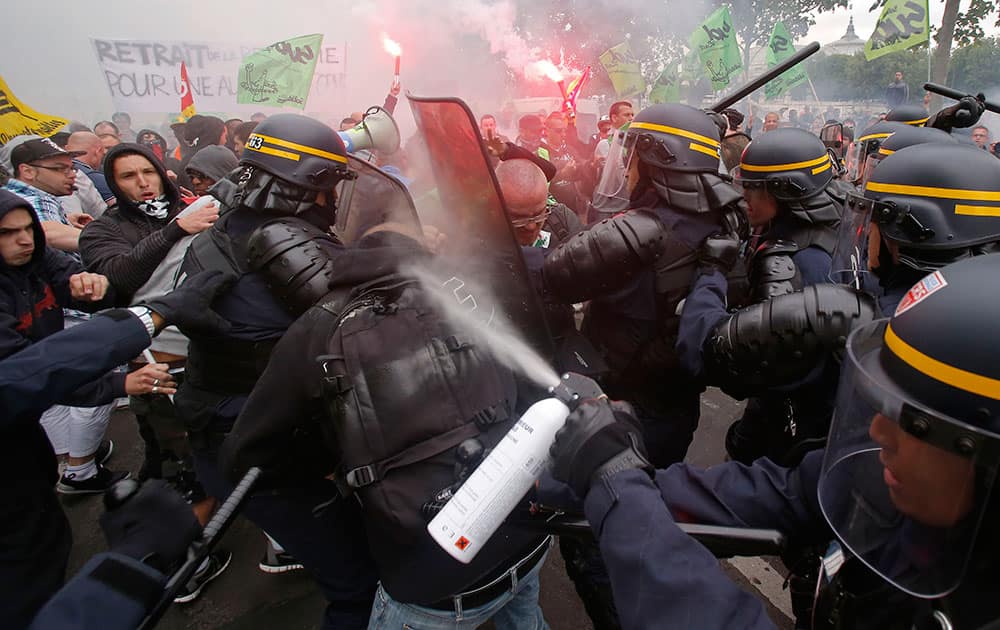 French riot police fire tear gas at striking train workers, during a protest over a bill to reform the state-run railway system in Paris.