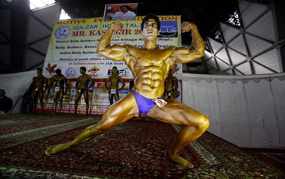 A Kashmiri body builder displays his muscles at a body building competition in Srinagar.